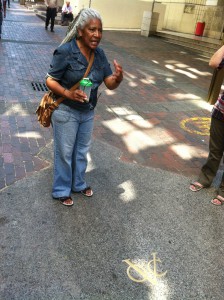 Lucy, our tour guide, explaining the meaning behind the gold "VOC" emblem in the sidewalk.