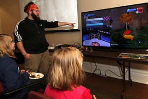 Tom Witkowski '15 walks kids  through a game he created at the inaugural Wabash Game Jam on April 27.