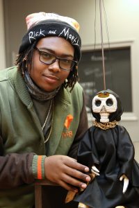 Lewis shows off his hand-carved creation in Lilly Library