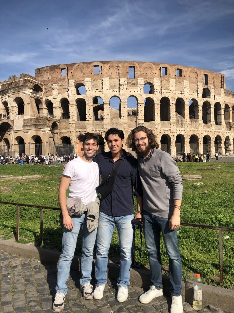 Jacob Maldonado and two other men stand in front of the Coliseum in Greece.