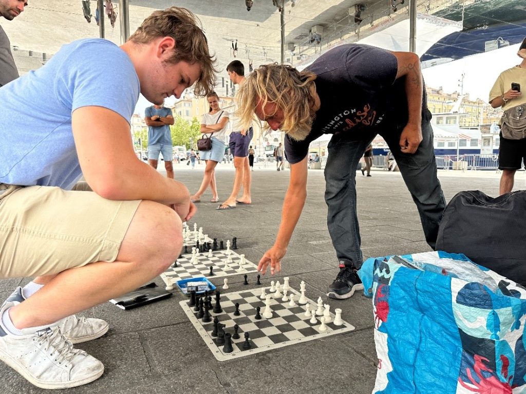 Two men playing chess in an open-air plaza